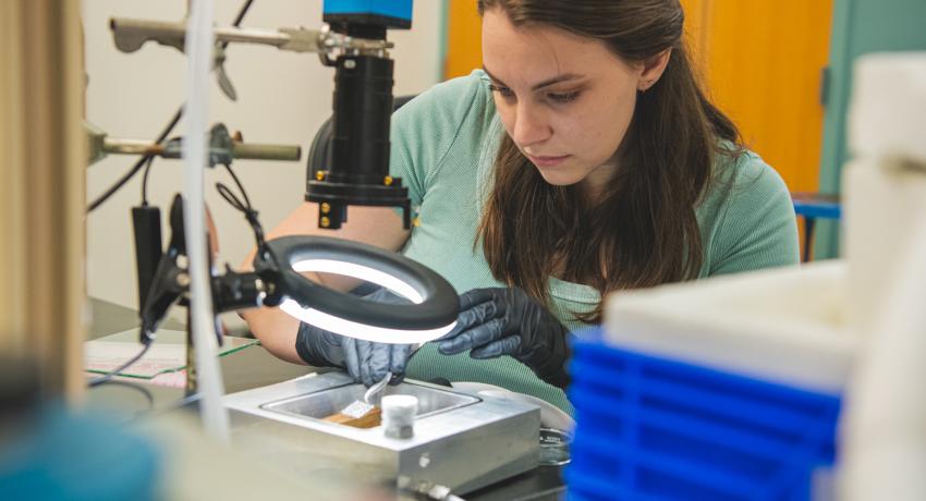 Woman in lab loading a sample to observe on a light tray